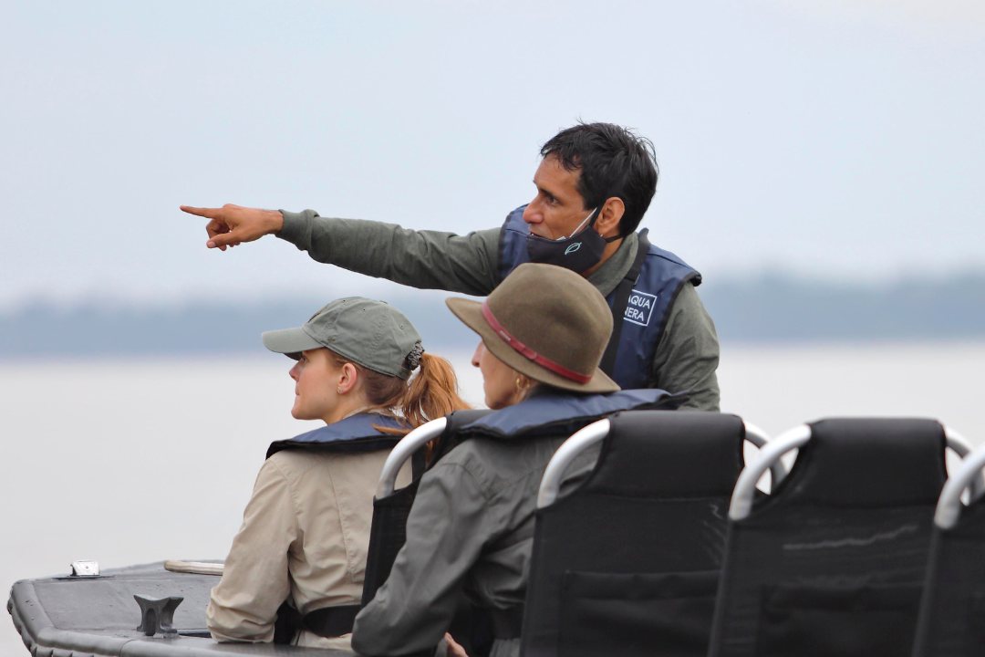 A naturalist guide pointing out wildlife from a skiff