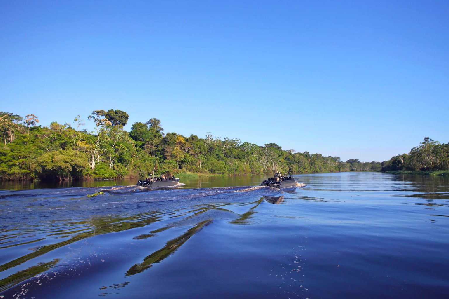 Skiffs crossing a wide blue river
