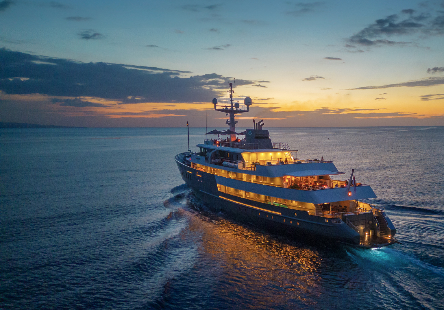Aqua Blu under way at dusk, her decks lit