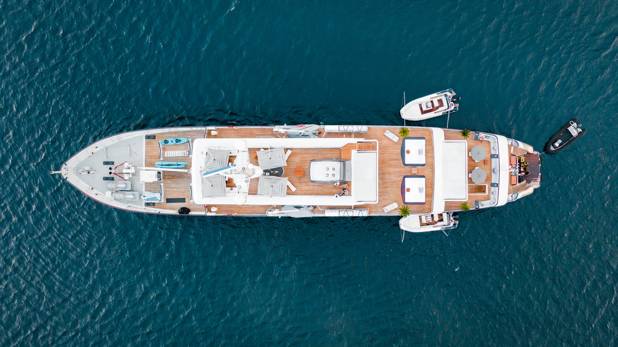 Aqua Blu on deep blue water with two tenders alongside, seen from directly above