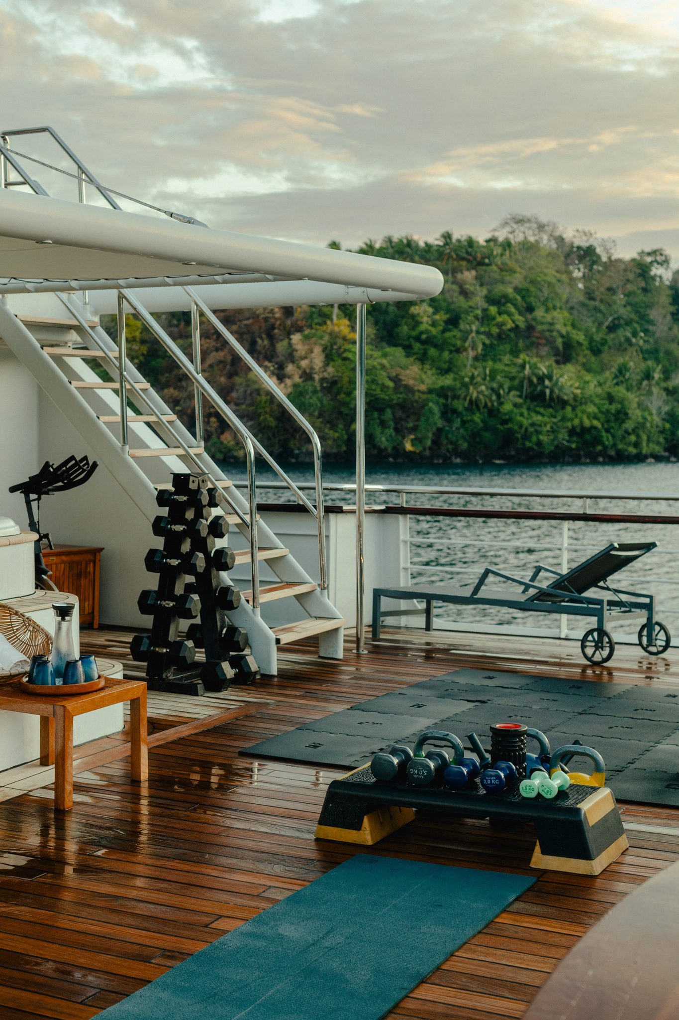 The outdoor exercise area, with weights and mats on the teak deck