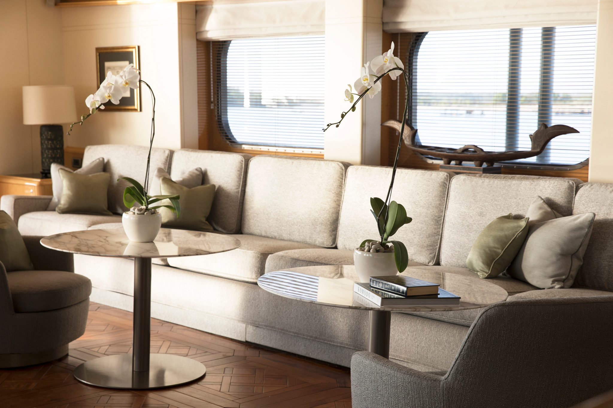 The Sky Lounge, with a long sofa, round tables with orchids and wide windows