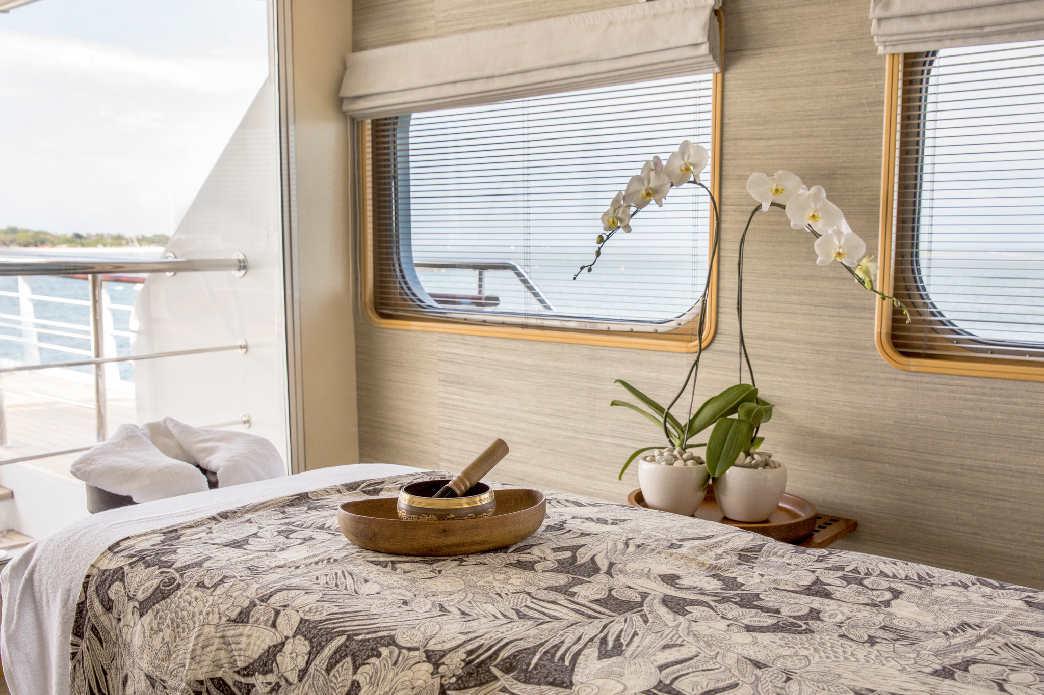 The spa room, with a massage table, orchids and windows onto the deck