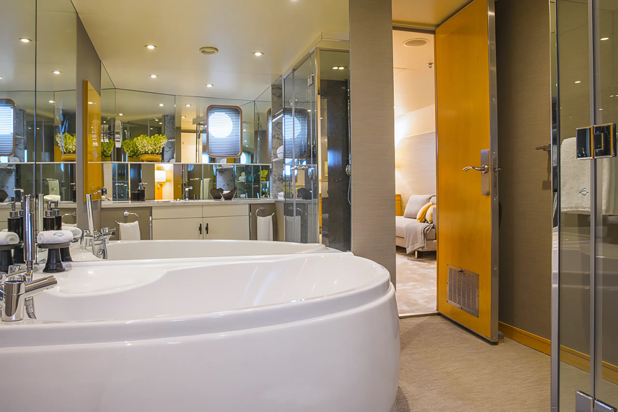The bathroom of cabin 101, with an oval bath and a glass-walled shower
